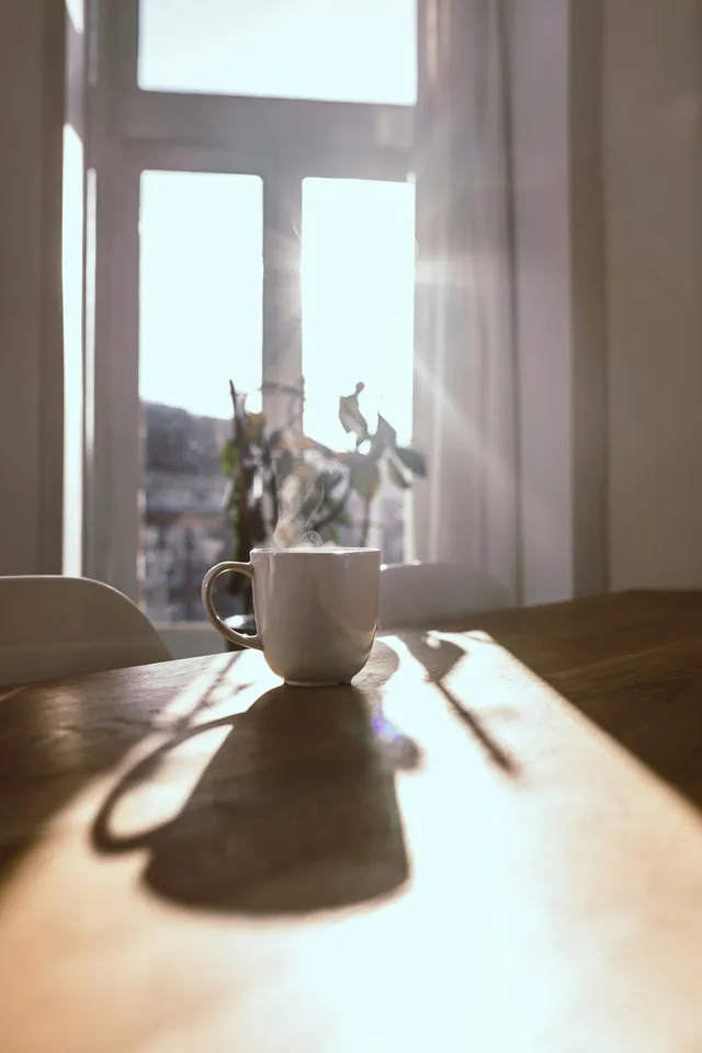 A mug of coffee on a sunlit kitchen table