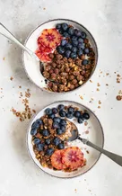 Two bowls of granola with berries